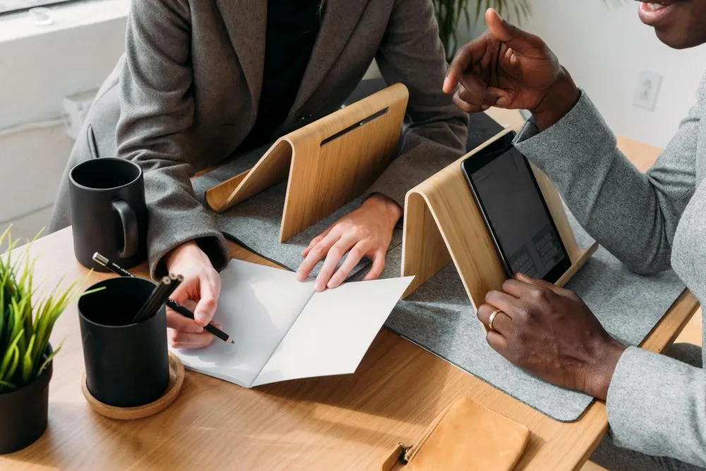 Two people reviewing paperwork together at a desk